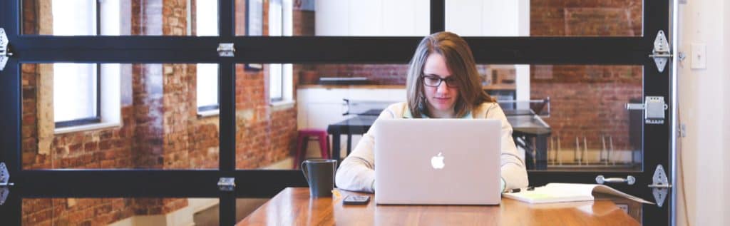 woman at desk looking at laptop